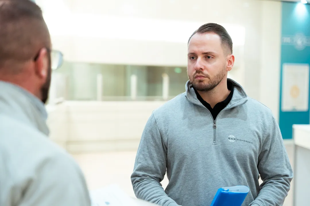 Zwei Mitarbeiter in einer Besprechung zum Sicherheitsdienst am Flughafen