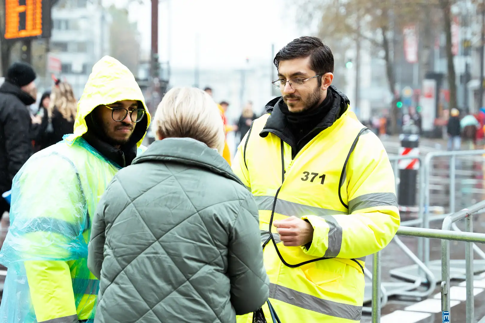 karneval-koeln Zwei Sicherheitsmitarbeiter geben einer Passantin eine Auskunft