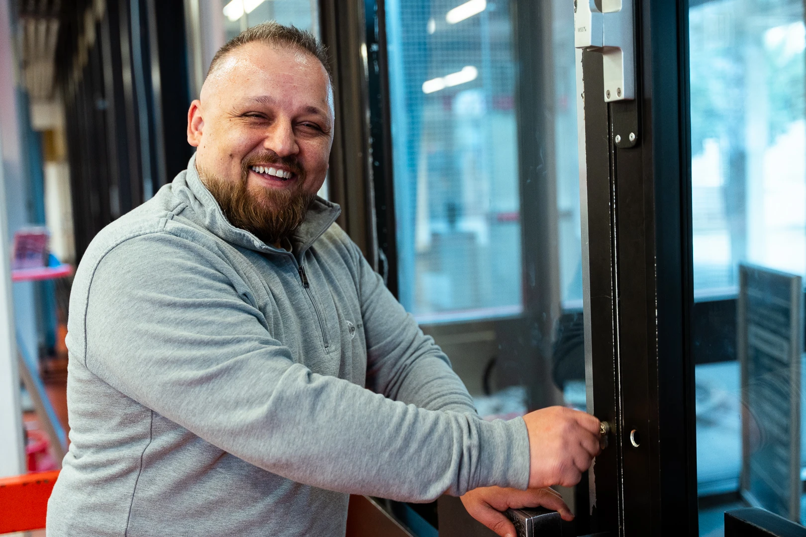 objektschutz-schließdienst Lächelnder Security Mitarbeiter schließt eine Tür im Einsatz im Objektschutz.